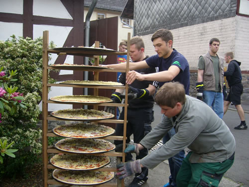 Die zubereiteten Pizzen werden vor dem Backhaus aufgestellt (Bild: Golz)
